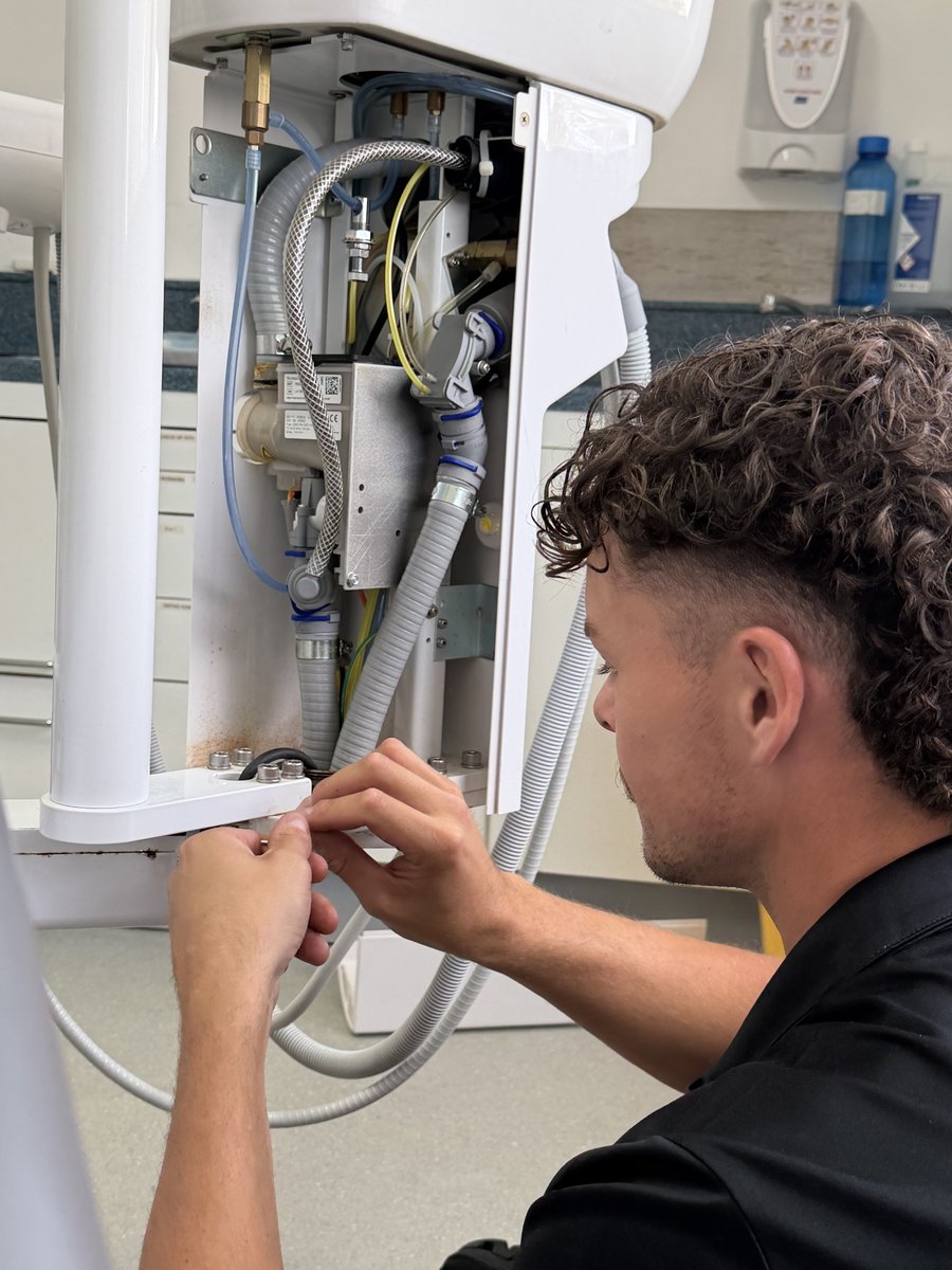 A Precision Dental Solutions engineer servicing the internals of a dental unit